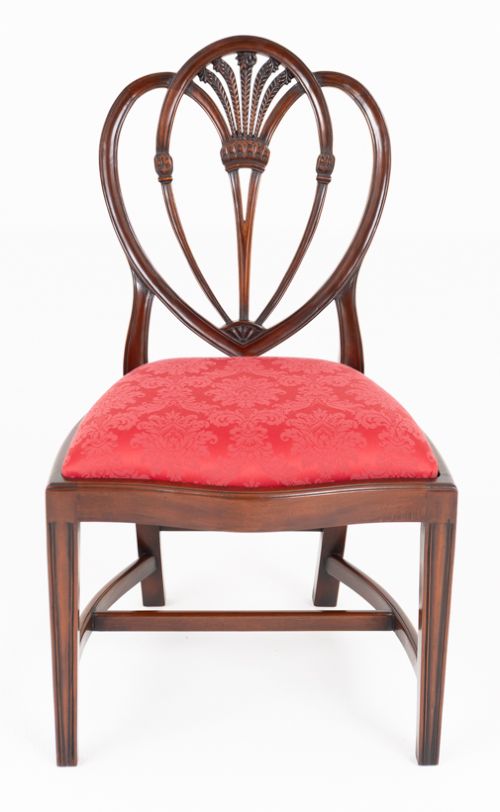 fig 2. A set of twelve mahogany dining chairs with carved Prince of Wales plume backs and red damask fabric seats arranged in a arc.