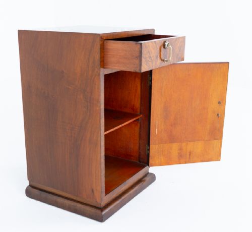 fig 2. An Art Deco burr walnut bedside cabinet featuring a single upper drawer above a lower cupboard door with brass pull handles.