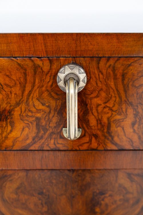 fig 3. An Art Deco burr walnut bedside cabinet featuring a single upper drawer above a lower cupboard door with brass pull handles.