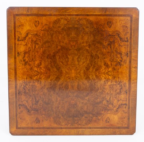 A square low coffee table crafted from warm brown burr walnut veneer with crossbanded borders, turned baluster legs, and curved stretchers. View V