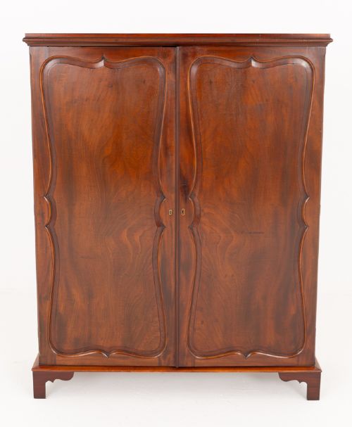 fig 1. A Georgian mahogany side cabinet featuring two cupboard doors with shaped panel mouldings, brass escutcheons, and bracket feet.