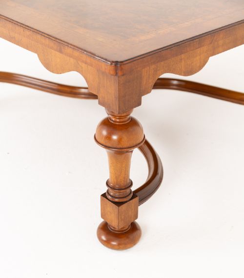 fig 1. A square walnut coffee table featuring a figured burr walnut top, turned baluster legs, and a curved X-stretcher base.