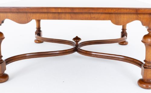 fig 2. A square walnut coffee table featuring a figured burr walnut top, turned baluster legs, and a curved X-stretcher base.