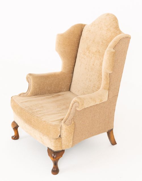 fig 1. A pair of Georgian style wingback armchairs with tan textile upholstery, hump backs, shaped side wings, and walnut cabriole front legs.