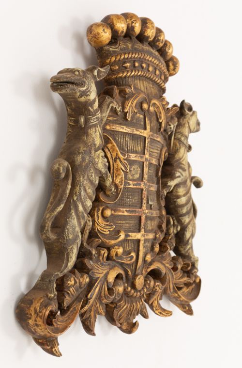 A gilded hardwood armorial shield featuring central cross quarterings flanked by two hound supporters and crowned with a ball-adorned coronet. View III