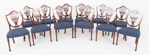 fig 1. A set of twelve mahogany Hepplewhite style dining chairs with shield backs, carved urn splats, and blue patterned upholstered seats.