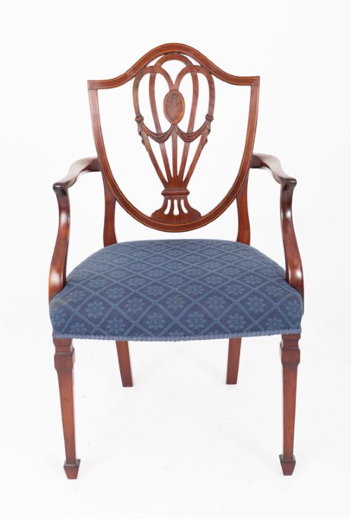 fig 2. A set of twelve mahogany Hepplewhite style dining chairs with shield backs, carved urn splats, and blue patterned upholstered seats.