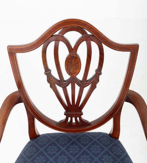 fig 4. A set of twelve mahogany Hepplewhite style dining chairs with shield backs, carved urn splats, and blue patterned upholstered seats.