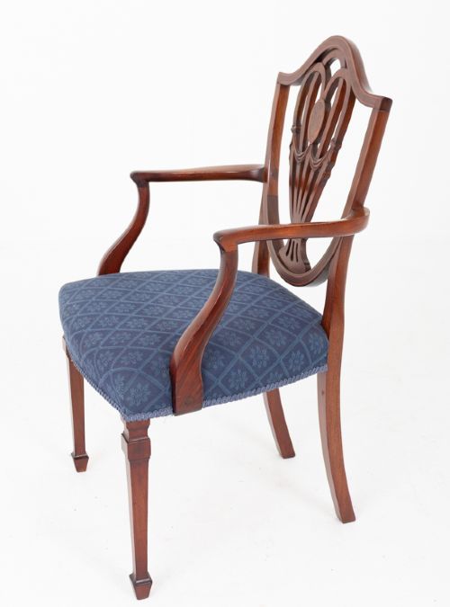 A set of twelve mahogany Hepplewhite style dining chairs with shield backs, carved urn splats, and blue patterned upholstered seats. View VI