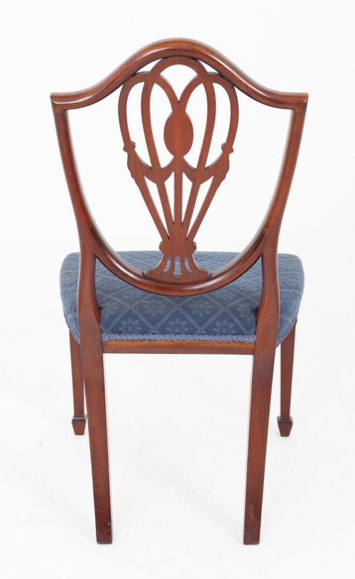 A set of twelve mahogany Hepplewhite style dining chairs with shield backs, carved urn splats, and blue patterned upholstered seats. View IX