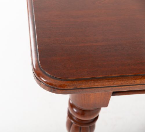 A Victorian mahogany extending dining table with two insertable leaves, fluted turned legs, and brass castors. View V
