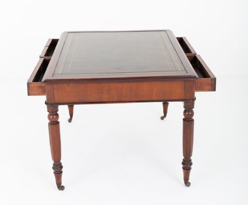 A Victorian mahogany partners writing table featuring a green leather inset top, turned legs on brass castors, and drawers with wooden knob handles. View VII