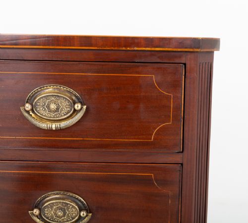 A Regency mahogany chest of four graduated drawers featuring brass oval backplate handles, reeded side pilasters, and splayed bracket feet. View VII