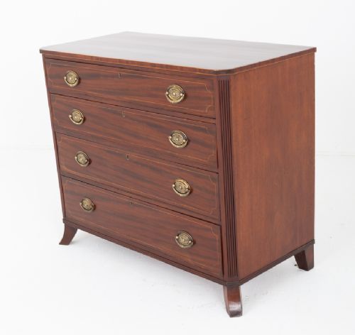 A Regency mahogany chest of four graduated drawers featuring brass oval backplate handles, reeded side pilasters, and splayed bracket feet. View IX