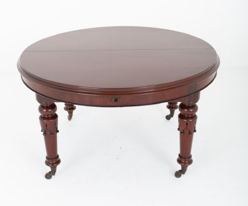 fig 1. A William IV mahogany extending dining table with turned carved legs and brass castors set against a plain white background.