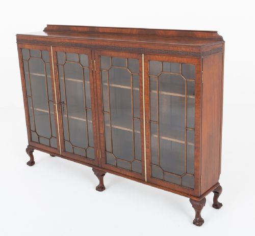 A low mahogany four-door side cabinet featuring geometric astragal glazed glass panels and carved claw and ball feet. View VII