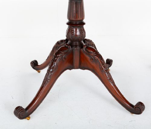 A large Regency style dark mahogany dining table featuring a three-pedestal base with carved splayed legs resting on brass castors. View V