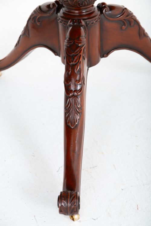 A large Regency style dark mahogany dining table featuring a three-pedestal base with carved splayed legs resting on brass castors. View VII
