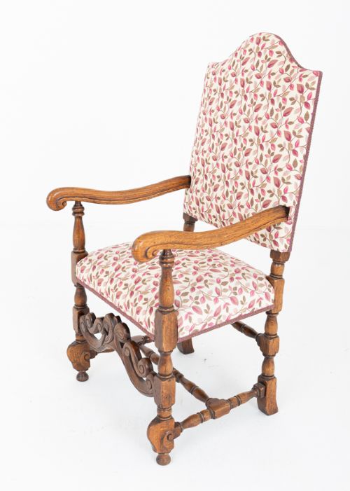 A set of eight Jacobean style oak dining chairs featuring carved scroll stretchers, turned legs, and floral leaf patterned fabric upholstery. View IV