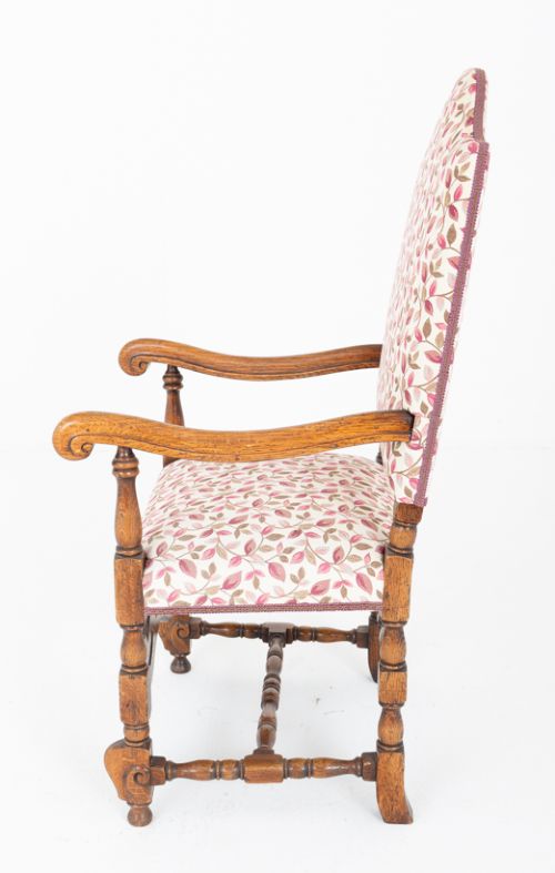 A set of eight Jacobean style oak dining chairs featuring carved scroll stretchers, turned legs, and floral leaf patterned fabric upholstery. View V