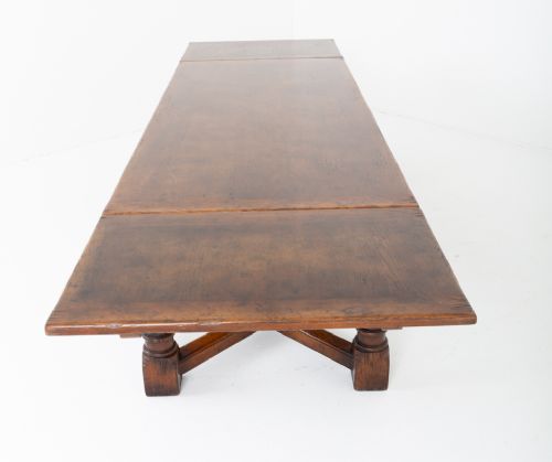 A dark oak Jacobean style extended refectory dining table featuring carved frieze detailing, turned legs, and lower stretchers. View VIII