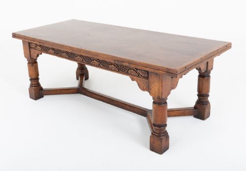 fig 1. A dark oak Jacobean style extended refectory dining table featuring carved frieze detailing, turned legs, and lower stretchers.