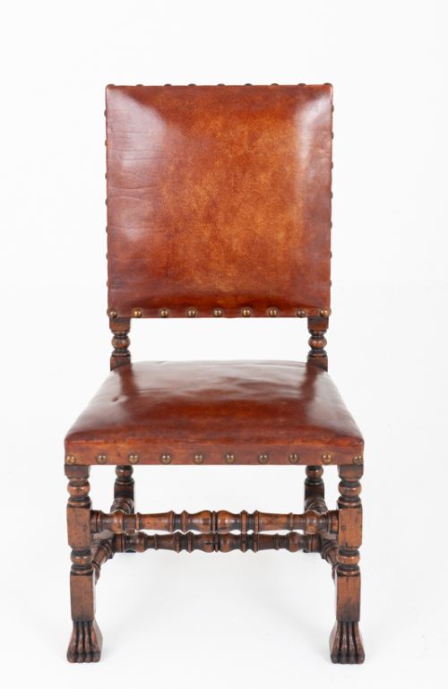 fig 1. A set of ten brown leather upholstered oak dining chairs with brass studding and turned stretchers, including two carvers and eight side chairs.