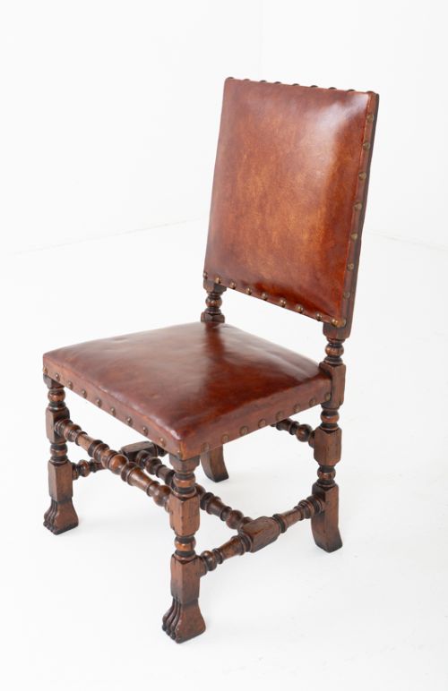 A set of ten brown leather upholstered oak dining chairs with brass studding and turned stretchers, including two carvers and eight side chairs. View III