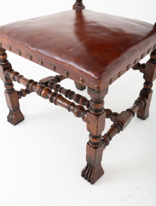 A set of ten brown leather upholstered oak dining chairs with brass studding and turned stretchers, including two carvers and eight side chairs. View IV