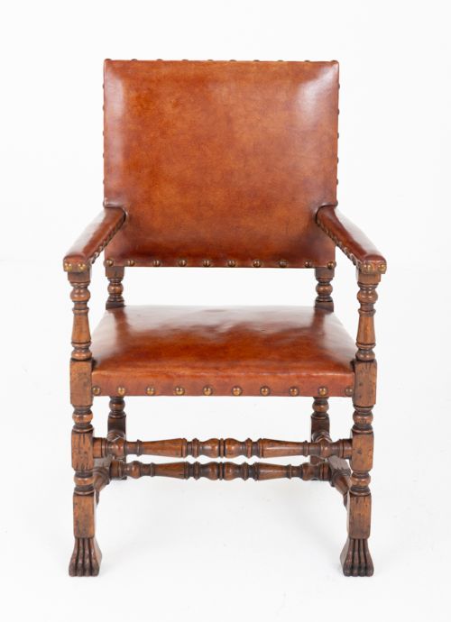 A set of ten brown leather upholstered oak dining chairs with brass studding and turned stretchers, including two carvers and eight side chairs. View VII