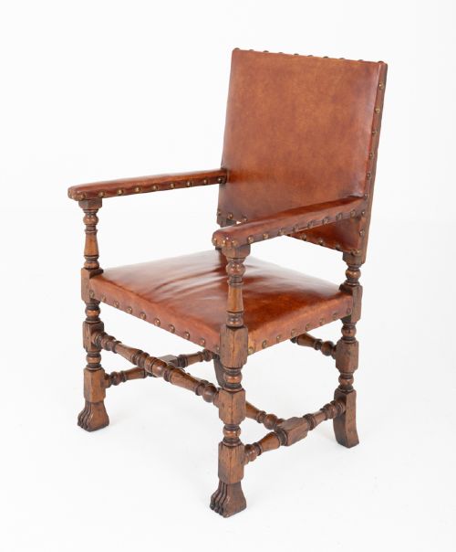 A set of ten brown leather upholstered oak dining chairs with brass studding and turned stretchers, including two carvers and eight side chairs. View VIII