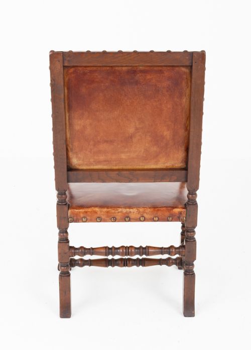 A set of ten brown leather upholstered oak dining chairs with brass studding and turned stretchers, including two carvers and eight side chairs. View XI