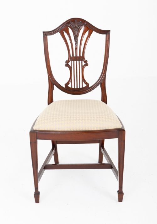 A set of ten mahogany Hepplewhite style dining chairs with shield backs and cream patterned upholstered seats. View VII