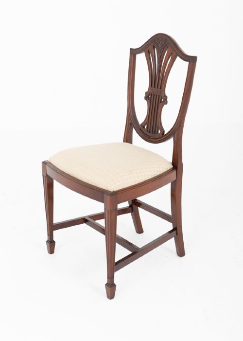 A set of ten mahogany Hepplewhite style dining chairs with shield backs and cream patterned upholstered seats. View VIII
