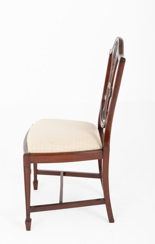 A set of ten mahogany Hepplewhite style dining chairs with shield backs and cream patterned upholstered seats. View IX