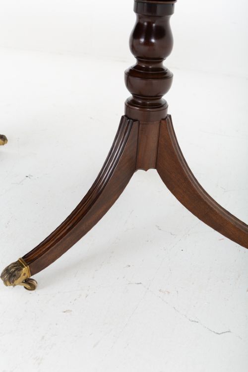 A large Regency Revival dark mahogany three-pedestal dining table with reeded splayed legs and brass claw castors. View V