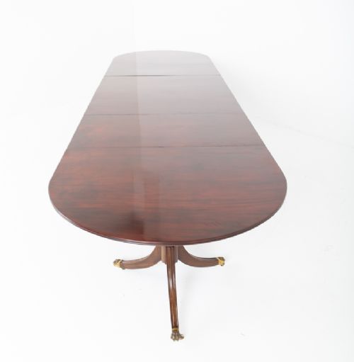 A large Regency Revival dark mahogany three-pedestal dining table with reeded splayed legs and brass claw castors. View XII