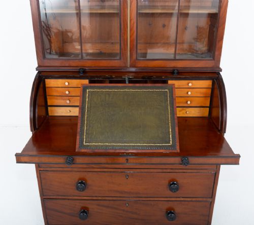 A Regency mahogany cylinder bureau bookcase featuring Gothic astragal glazed upper doors above a curved roll-top desk and three long drawers with turned dark handles. View VII