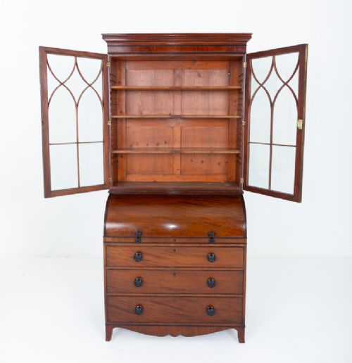 A Regency mahogany cylinder bureau bookcase featuring Gothic astragal glazed upper doors above a curved roll-top desk and three long drawers with turned dark handles. View VIII