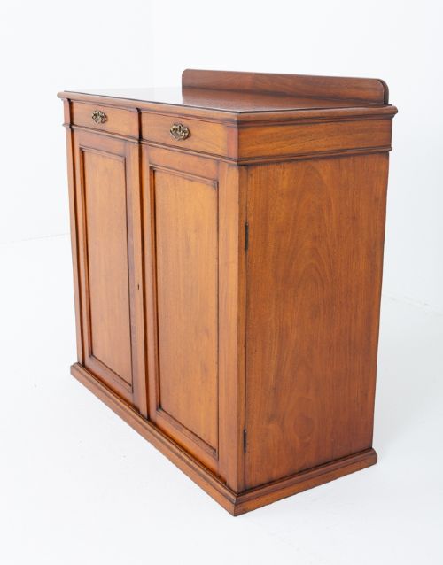 fig 2. A Victorian mahogany side cabinet featuring two top drawers with brass drop handles above two panelled cupboard doors and a low top gallery.