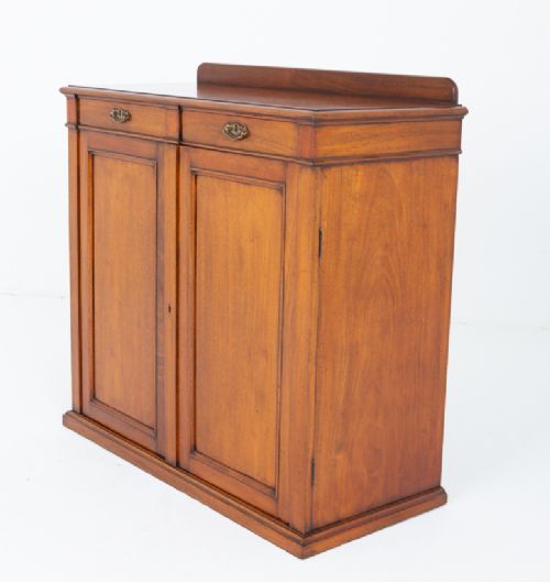 A Victorian mahogany side cabinet featuring two top drawers with brass drop handles above two panelled cupboard doors and a low top gallery. View VII