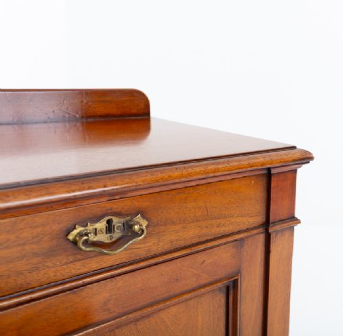 A Victorian mahogany side cabinet featuring two top drawers with brass drop handles above two panelled cupboard doors and a low top gallery. View IX