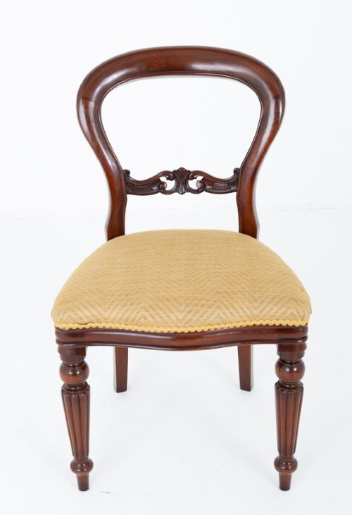 A set of eight Victorian style mahogany dining chairs with rounded balloon backs, carved mid-rails, gold upholstered seats, and fluted front legs. View III
