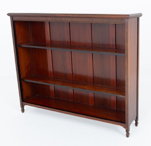 A wide Victorian open mahogany bookcase featuring a panelled back, two horizontal shelves, and turned feet. View VIII