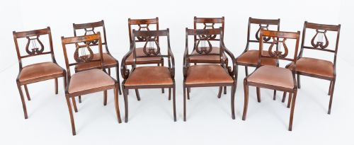 fig 1. A set of ten mahogany Regency style dining chairs featuring carved lyre back splats, curved armrests on two carvers, and rust-coloured upholstered seats.