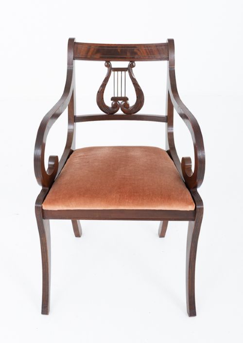 fig 2. A set of ten mahogany Regency style dining chairs featuring carved lyre back splats, curved armrests on two carvers, and rust-coloured upholstered seats.