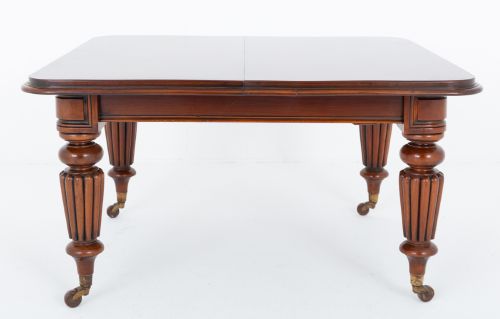 fig 1. A William IV mahogany extending dining table with three additional leaves, standing on turned and reeded legs with brass castors.