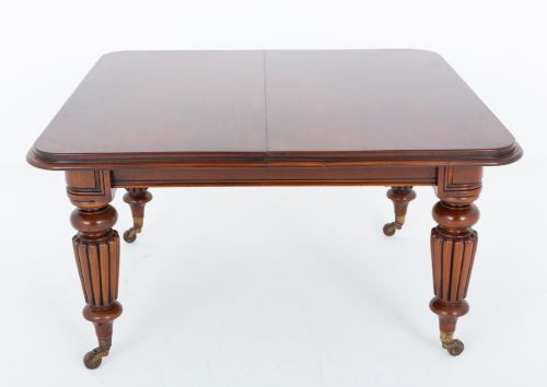 fig 2. A William IV mahogany extending dining table with three additional leaves, standing on turned and reeded legs with brass castors.