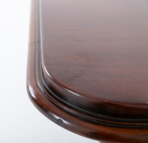 A William IV mahogany extending dining table with three additional leaves, standing on turned and reeded legs with brass castors. View V