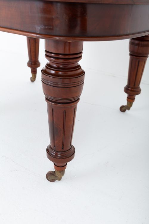 fig 2. A Victorian mahogany extending dining table with two removable extension leaves, turned fluted legs, and brass castors.